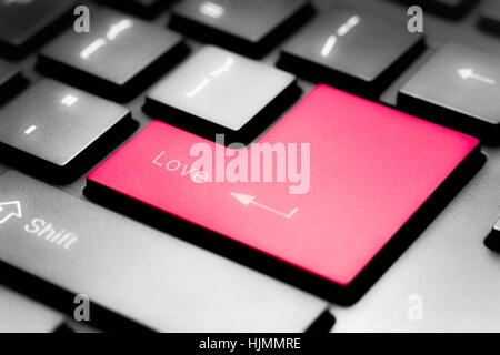 Grey keyboard with red enter button with Love on it Stock Photo
