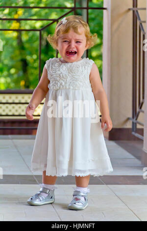 Cute crying baby girl with blond hair Stock Photo