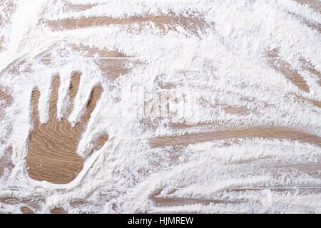 female palm print on flour scattered on the kitchen board. horizontal closeup Stock Photo