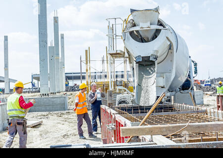 Zrenjanin, Vojvodina, Serbia - May 29, 2015: Workers at building site are pouring concrete in mold from mixer truck. Stock Photo