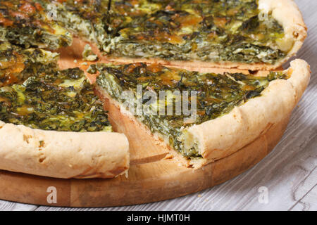 tasty and healthy chopped spinach pie with a close-up on a cutting board. horizontal. Stock Photo