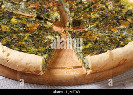 sliced pie with spinach and soft cheese closeup on chopping board. horizontal. Stock Photo
