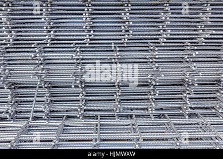 Spikes of rebar grid, reinforcing mesh, steel bars stacked for construction. Stock Photo