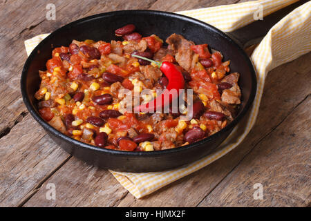 Mexican food is chili con carne in a frying pan on a wooden background closeup Stock Photo