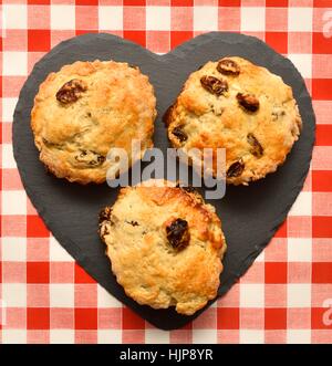 3 scones on a heart shaped piece of slate. Stock Photo