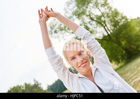 Young happy woman making wellness exercises in the nature Stock Photo