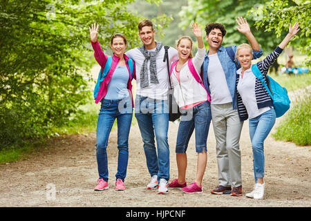 Friends waving and smiling with joy as a group Stock Photo