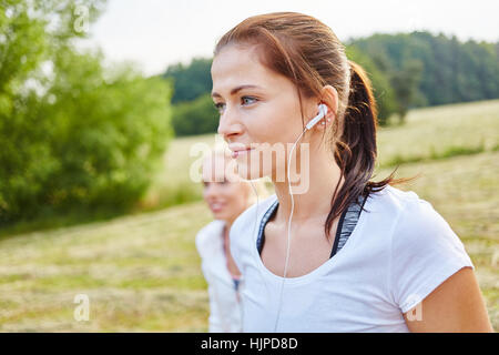 Young athlete woman listening to music with mp3 player in the nature Stock Photo
