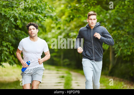 Two young men running in the park Stock Photo