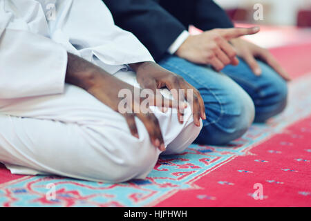 Two religious muslim man praying together inside the mosque Stock Photo