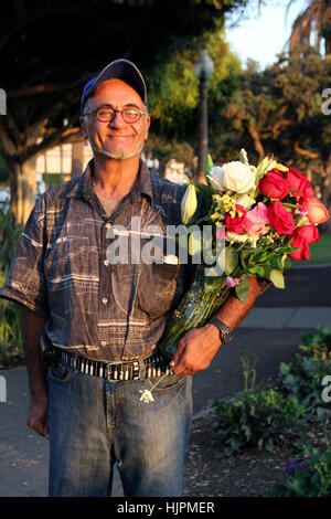 A flower vendor in Santa Monica, California. He has a belt with a keys like a piano. Stock Photo