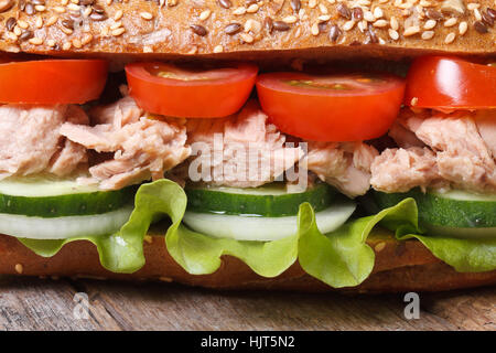 Delicious sandwich with tuna and vegetables on an old table macro. horizontal Stock Photo