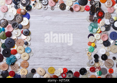 Frame of old buttons on wooden background close-up horizontal view from above Stock Photo