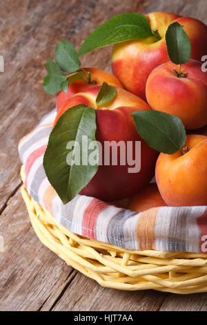 Fresh juicy nectarine, peaches and apricots in a basket closeup vertical Stock Photo