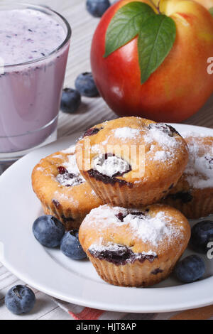 blueberry muffins, fresh peaches and a milkshake closeup on a wooden table. vertical Stock Photo