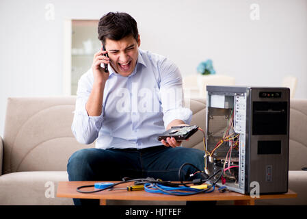 Angry customer trying to repair computer with phone support Stock Photo