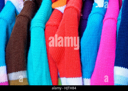 colorful wool sweaters hung vertically and profile Stock Photo