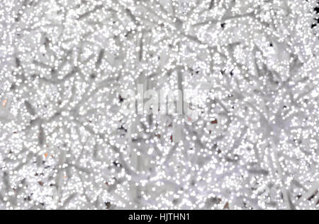 Christmas tree with artificial branches structure covered with a dense network of very white light and very bright with rare golden yellow lights flas Stock Photo