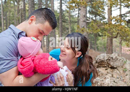 Parents playing with and kissing baby girl Stock Photo
