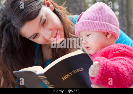 Baby girl and mom reading KJV Bible (King James Version) Stock Photo