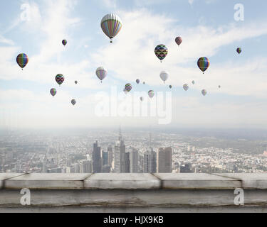 Colorful aerostats flying in clear sky above modern city Stock Photo ...