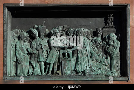 Bronze relief devoted to the benefits of book printing for Asia on the monument to Johannes Gutenberg (1840) by French sculptor David d'Angers in Strasbourg, Alsace, France. British philologist William Jones (L) and French Indologist Abraham Hyacinthe Anquetil-Duperron (R) are depicted next to the printing press in the centre. Sultan Mahmud II of the Ottoman Empire is depicted in the left surrounded by the Brahmans exchanging manuscripts for books and Chinese people reading Confucius. Stock Photo