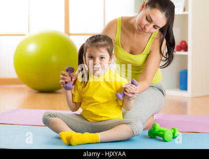 Mom and child daughter engage in fitness dumbbells Stock Photo