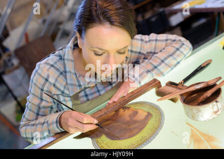 Artist doing detailed painting Stock Photo