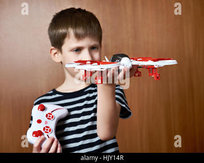 Little boy with toy quadrocopter drone at home Stock Photo