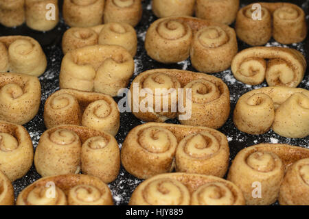 raw cookie dough with cinnamon formed in brezel shape waiting to be cooked in the oven. Stock Photo