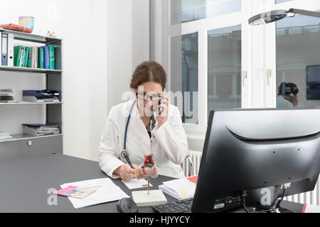 Female doctor  consulting patients over the telephone Stock Photo