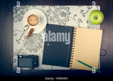 Notepad, cup of coffee, smartphone and digatal capera on the desktop. Journey planning concept Stock Photo