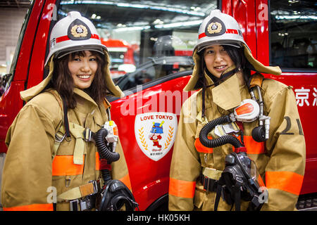 Two girls dressed as firefighters, during Dezomeshiki or New Year parade by the Tokyo Fire Department, Tokyo, Japan Stock Photo