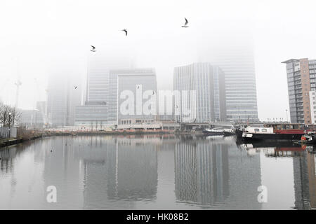 Fog clouds the view of Canary Wharf in London's Docklands. Stock Photo