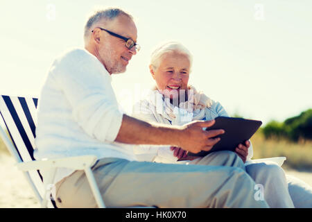 happy senior couple with tablet pc on summer beach Stock Photo