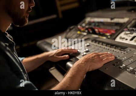 man using mixing console in music recording studio Stock Photo