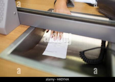clerk giving receipt at bank or currency exchanger Stock Photo