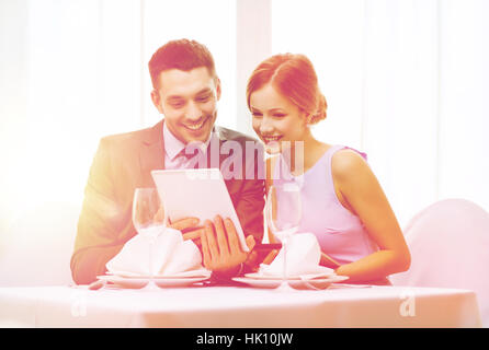 couple with menus on tablet pc at restaurant Stock Photo