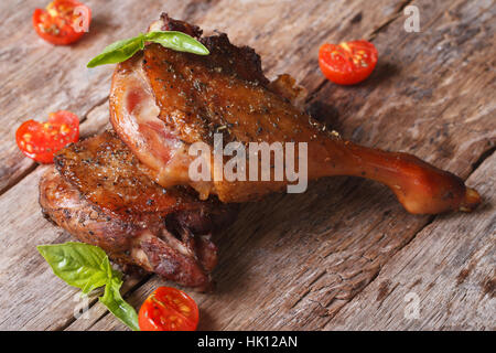 two fried duck legs and basil, cherry tomatoes close up on an old table horizontal Stock Photo