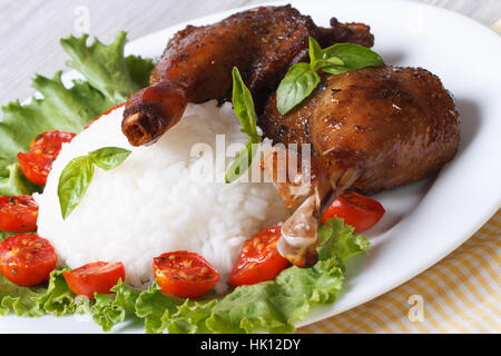 Rice with duck leg quarters on a plate with lettuce and tomatoes closeup horizontal Stock Photo