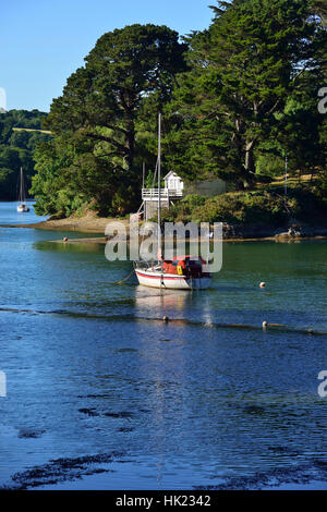 Scenic view of moored boat taken from St Just in Roseland churchyard looking across the tidal creek off the Fal Estaury, Roseland,Cornwall, UK Stock Photo