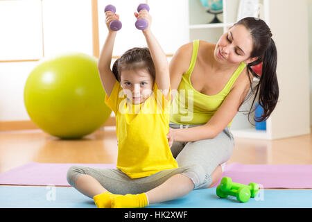 family mother and child daughter are engaged in fitness, yoga, exercise at home or sport hall Stock Photo