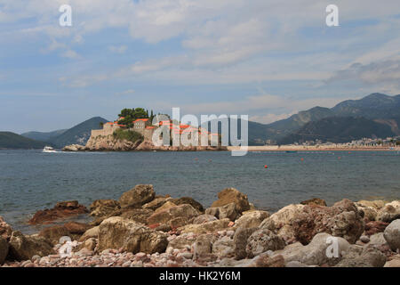 Coastal boulders close up on a background of the island of Sveti Stefan, Montenegro Stock Photo
