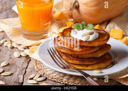 Pumpkin pancakes with sour cream and juice with pulp closeup horizontal Stock Photo