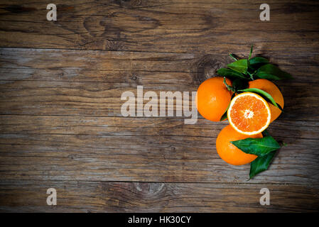 Fresh oranges sliced on old wooden table Stock Photo