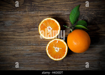 Fresh oranges sliced on old wooden table Stock Photo