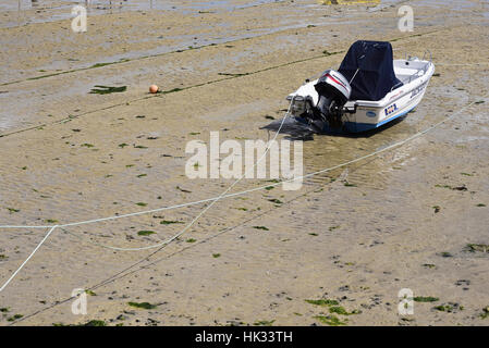 Moored motor boat in St Ives harbour, Cornwall, at low tide, showing mooring ropes and wet sand Stock Photo