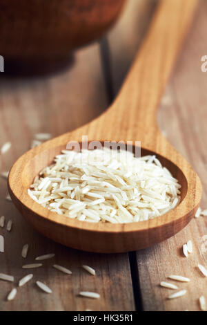 Closeup of raw uncooked basmati rice in wooden spoon Stock Photo