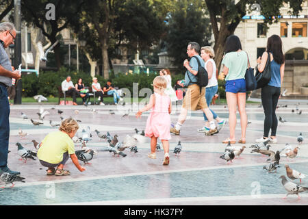 Barcelona, Spain - August 25, 2014: Children and doves are on placa de Catalunya in Barcelona Stock Photo