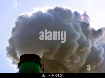 Factory flue and water steam on a blue sky background. Stock Photo